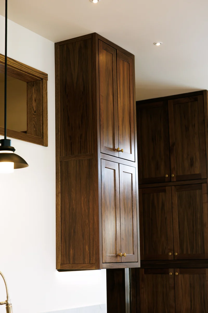 Soldotna Gourmet Kitchen — Walnut Cabinetry Tower & Textured Brass Hardware